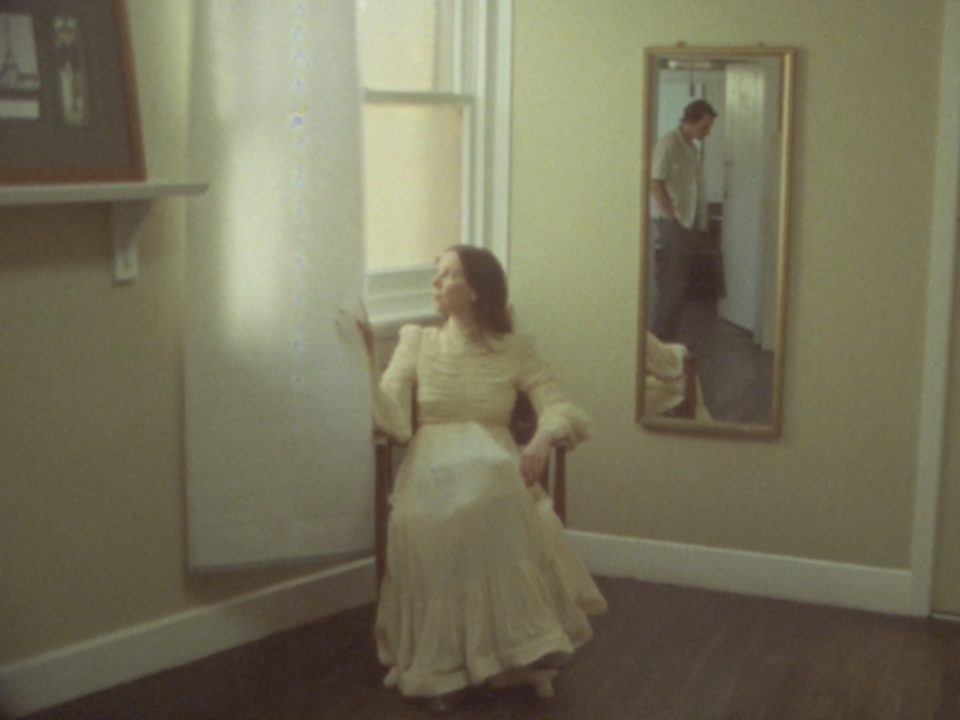 Frame from the Serene Dreams music video — a woman in a yellow dress seated in a room